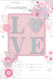 The anniversary card pictured here offers a gentle celebration of enduring love, composed in a soothing mix of pastel pinks, silvery greys, and warm whites that would pair beautifully with a soft-toned bouquet arriving at an EC2 office or flat. At its heart, the word LOVE is rendered in raised, glitter-soft letters, each curve and edge catching the light with a refined shimmer. The O is imaginatively replaced by a textured silver heart, giving the central word both visual impact and a tactile focus, like the smooth gleam of a metallic ribbon wound around anniversary flowers delivered near Liverpool Street or Old Broad Street. Surrounding this motif, delicate blossoms unfurl in blush and mauve tones, their shapes softened as though painted in watercolour. Faint lines trace their stems and leaves, curving in elegant arcs that frame the central word without overwhelming it. Tiny flourishes-floating petals, swirling motifs, and subtle butterfly silhouettes-add a sense of gentle motion, suggesting blossoms drifting in a light breeze through the City. Phrases like On Our Anniversary and I love you today and always appear in a refined, flowing script, their understated style reinforcing the authenticity of the sentiment. The balance of soft colour, shimmering accents, and open space creates a sense of intimacy and quiet celebration, making this card feel like a cherished keepsake, much like the memory of a surprise bouquet from EC2 Flowers waiting on a desk at the end of a long day in the heart of London.
